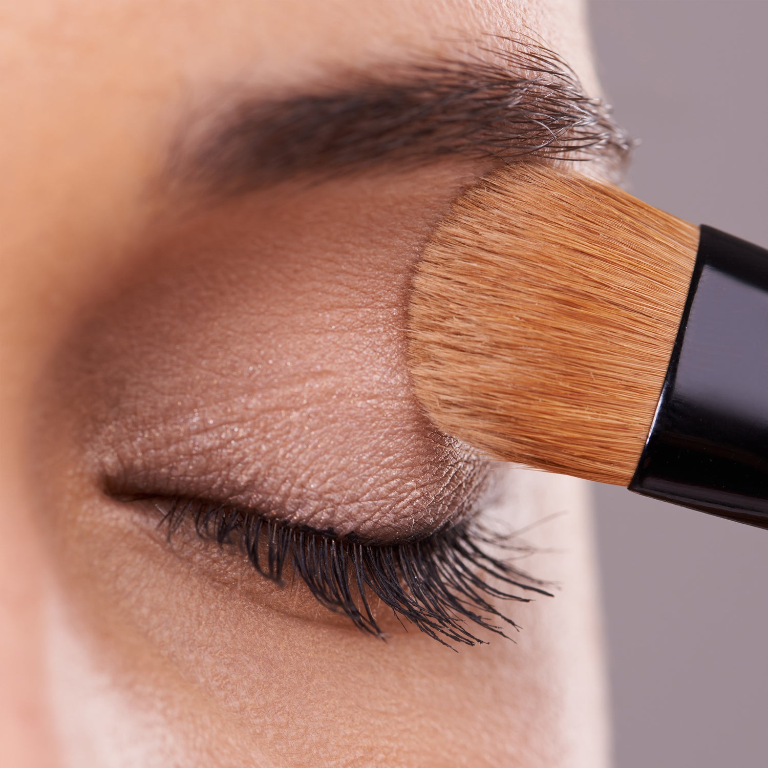 Woman applying makeup to her beautiful eyes